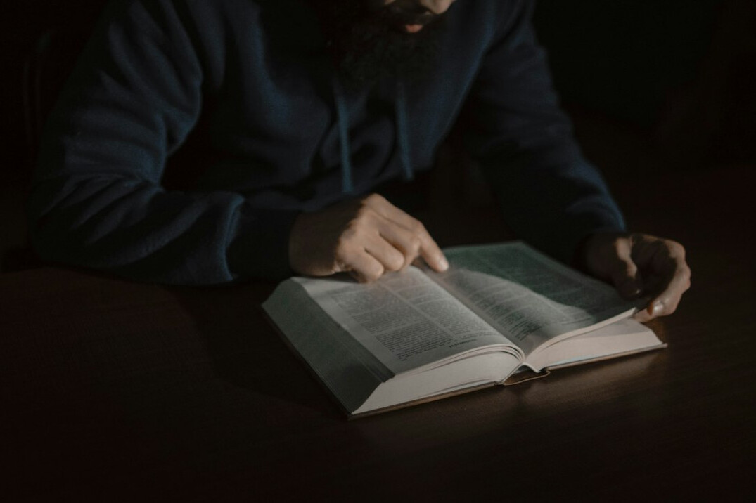 person reading mystery book at night